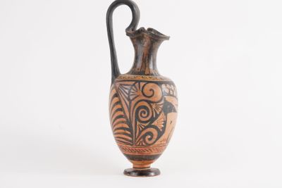 a vase that is sitting on a stand on a white surface