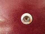 the inside of a red leather purse with a metal button