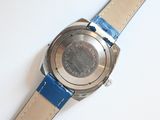 a close up of a watch on a white surface