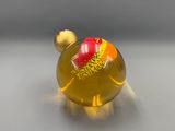 a yellow glass bottle with a red flower inside of it