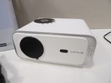 a white projector sitting on a table next to a box