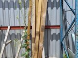 Plusieurs morceaux de bois sont empilés sur une palette devant un bâtiment
