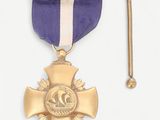 purple and gold medal with a white ribbon and a gold pin