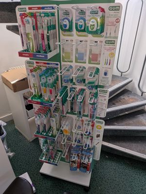 un présentoir de brosses à dents et de dentifrice dans un magasin