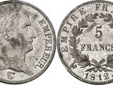 a silver coin with a woman ' s head and laurels on it