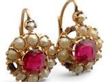 une paire de boucles d'oreilles en rubis et perles sur fond blanc