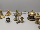many different types of brass objects displayed on a table