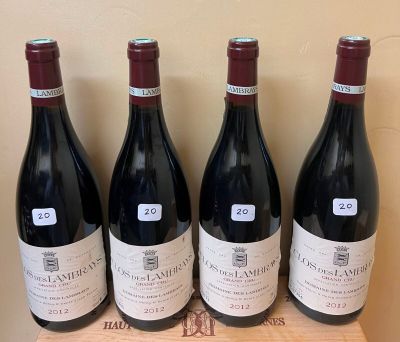 four bottles of red wine are lined up on a wooden box