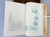 an open book with drawings on it on a table