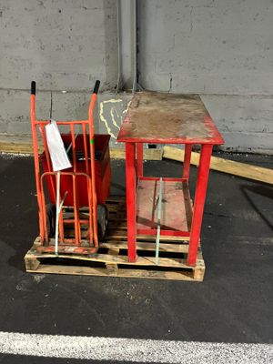 une petite table et une chaise posées sur une palette dans un parking