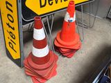 yellow and white street sign sitting next to orange traffic cones