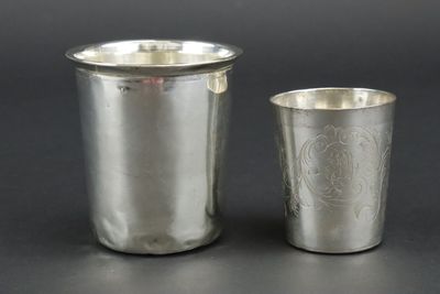two silver cups sitting next to each other on top of a table