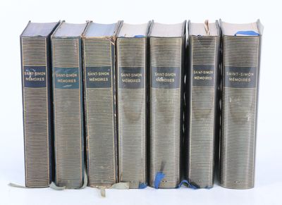 six vieux livres sont alignés sur une surface blanche