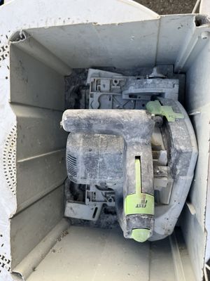 une machine sale à l'intérieur d'une boîte blanche posée par terre