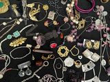many different types of necklaces and bracelets laid out on a table