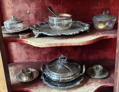 une étagère sur laquelle sont disposés de nombreux objets en argent