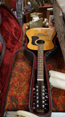 une guitare posée dans son étui, par terre