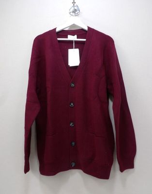 a close up of a sweater hanging on a hanger on a wall