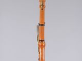 a close up of a wooden clarinet on a clear surface