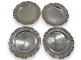 four silver plated coasters with decorative designs on them