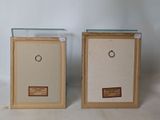 pair of framed glass display cases with labels on them on a white surface