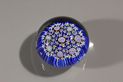 un objet en verre bleu et blanc posé sur une surface blanche