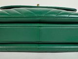 green leather handbag with chain strap on white background