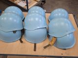 several helmets are lined up on a table in a warehouse