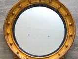 un miroir doré orné d'un aigle, accroché au mur