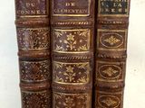 quatre vieux livres sont empilés les uns sur les autres, alignés en rangée