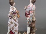 pair of figurines of a woman and a man with a basket of flowers