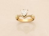 a gold ring with a heart shaped diamond on it