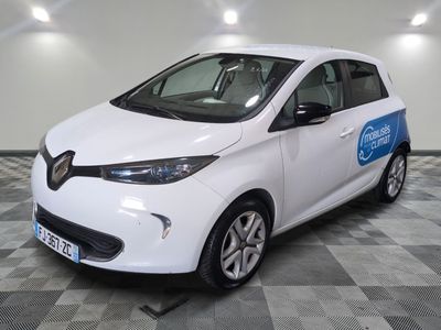 la petite voiture blanche est garée dans le garage sur un sol en damier