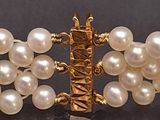 a close up of a bracelet with pearls on it