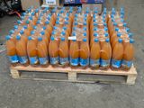 de nombreuses bouteilles de jus d'orange posées sur une palette