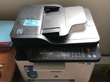 a printer sitting on top of a desk next to a stack of books