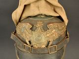 an old hat with a bird on it sitting on top of a metal stand