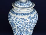 blue and white vase with a lid on a dark background
