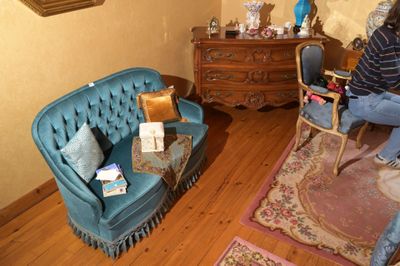 une femme assise sur un canapé bleu dans un salon