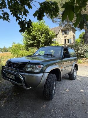 une photo d'une voiture garée sur un chemin de gravier