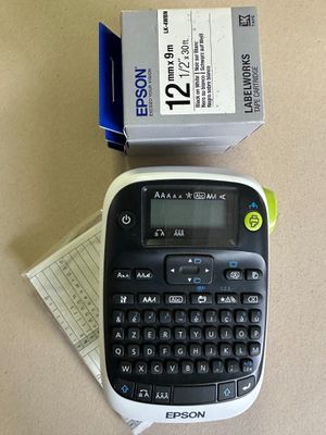 a black and white label printer next to a box of labels