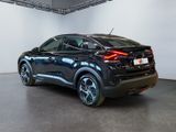 the rear end of a black car in a white room