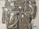 six sacs de vêtements emballés dans du plastique, posés sur une table