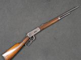 un fusil Winchester avec une crosse en bois et un canon plaqué argent
