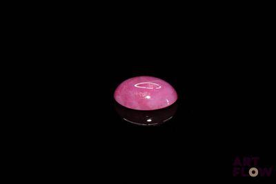 a pink candle that is lit up in the dark