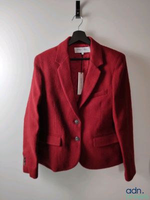 a red jacket hanging on a hanger on a wall