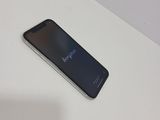 the back of a black cell phone sitting on top of a white table
