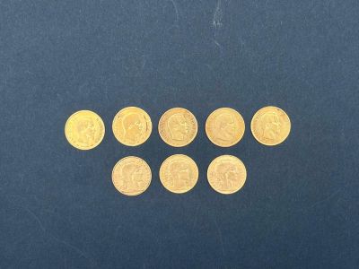 un gros plan sur un tas de pièces d'or posées sur une surface bleue