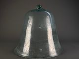 a glass bell with a green top on a table