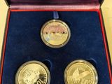 two gold coins in a red box on a table